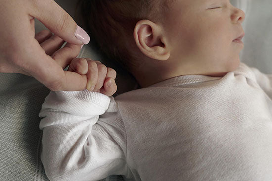 baby holding adult finger