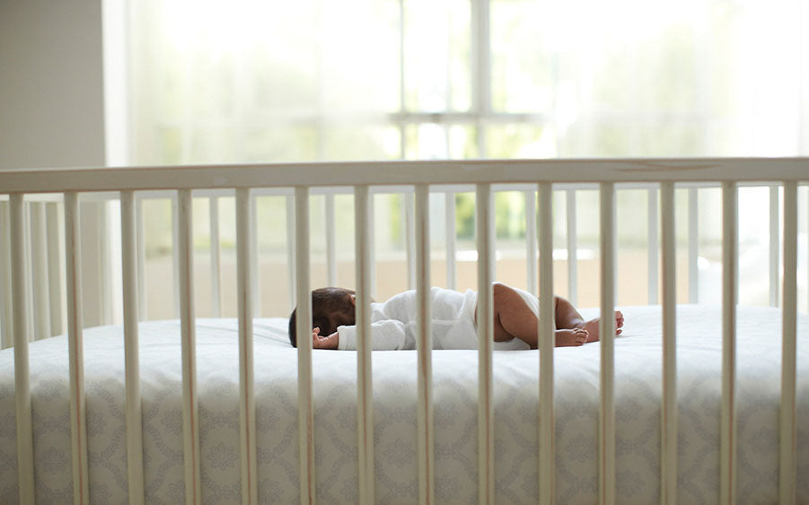 A peaceful baby rests in their crib, dreaming sweet dreams.