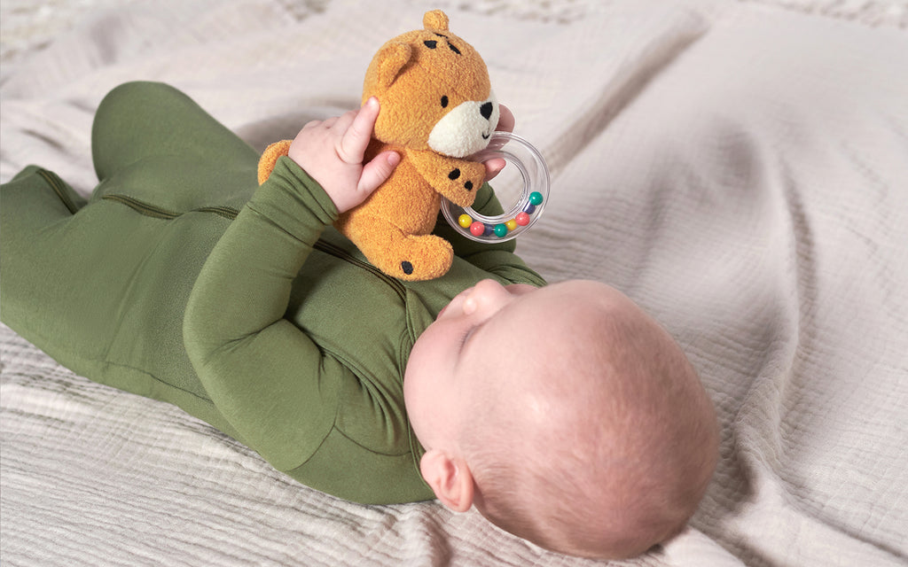 A serene infant nestled on a plush bed, accompanied by a cuddly teddy bear, exuding an aura of innocence and tranquility.