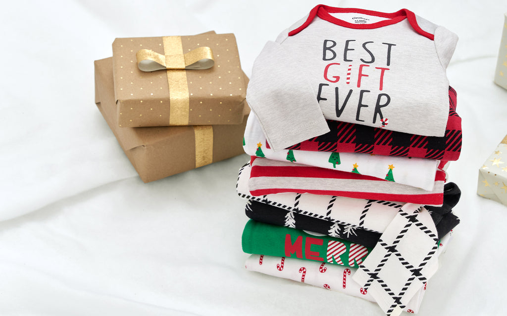 Capture the joy of the holiday season with this heartwarming image of a baby t-shirts surrounded by a pile of Christmas gifts.