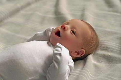 Newborn baby white onesie bodysuit yawning