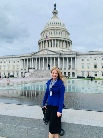 Woman with blonde hair standing standing in front of the capitol building