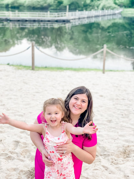 Two friends, Lena and Brooklynn, wearing contagious smiles while cherishing a beautiful moment of motherhood..