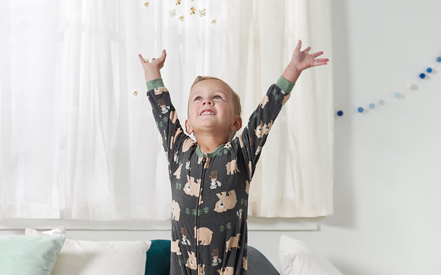 A joyful toddler in cozy pajamas leaps high with glee, embracing the freedom of the moment. Pure happiness captured in mid-air!