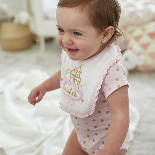 Adorable baby girl in a pink polka dot bib, ready for mealtime!