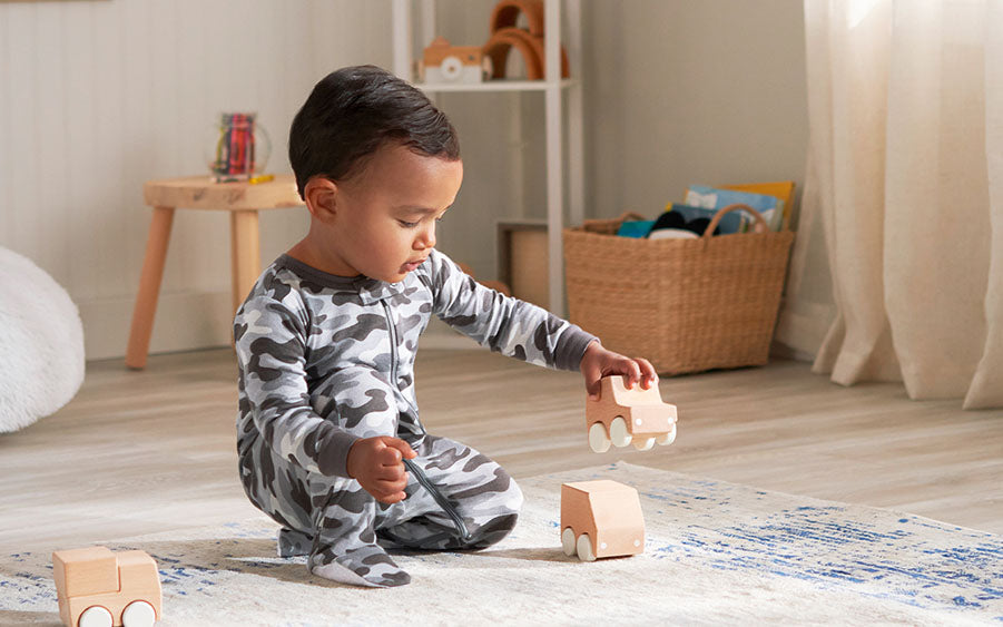 Watch out, future architect in the making! Toddler engrossed in building with wooden blocks.