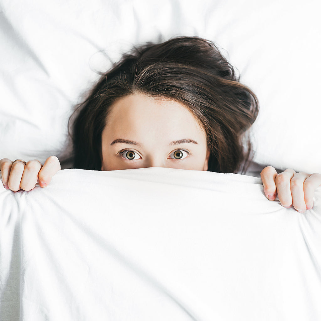 Peeking out from sheets after learning how to make your mattress and bedding last