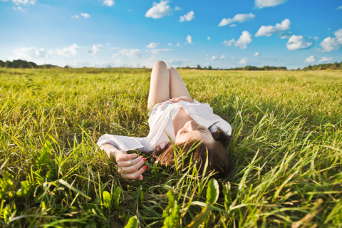 a woman touching herself in a grassy field