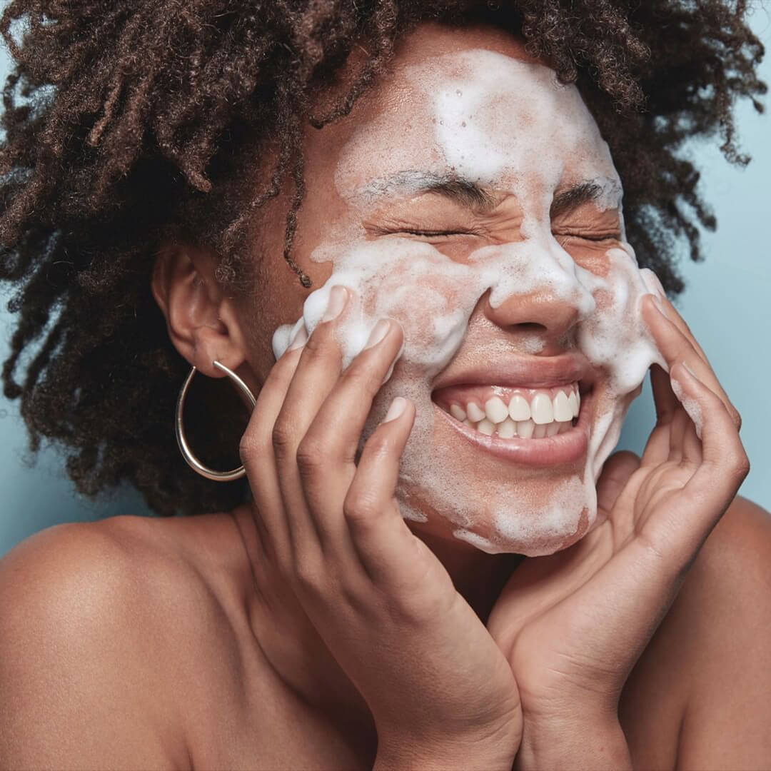 woman-cleans-face-with-cream