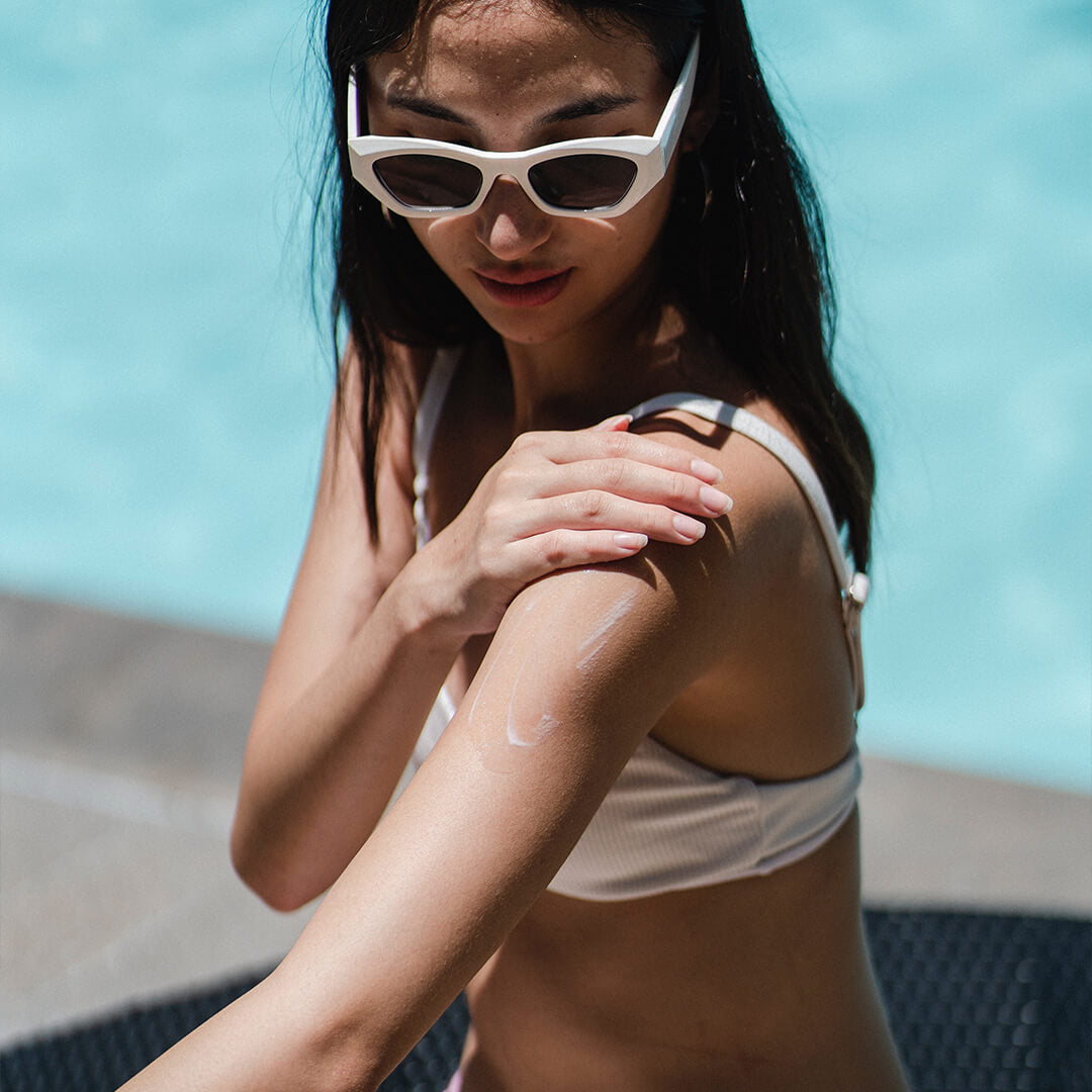 woman-using-sun-cream-on-arm