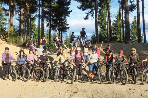 Group photo of bike riders on top of a forest mountain top