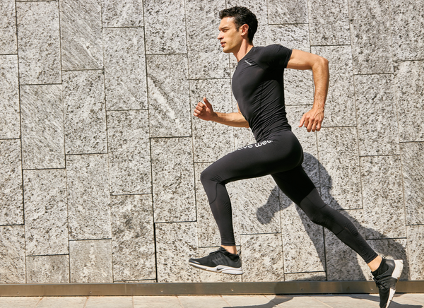 Man mid run as he is wearing the wavewear leggings and compression top