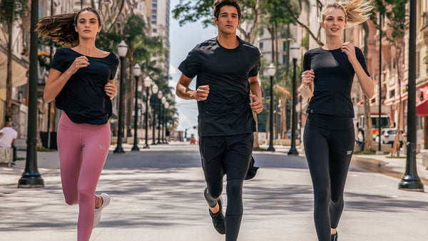 three models running down the street together wearing athletic wear, mid running shot