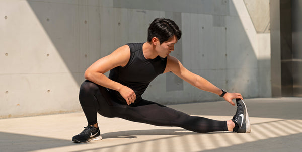 Man doing a one leg split stretch in a squatting position