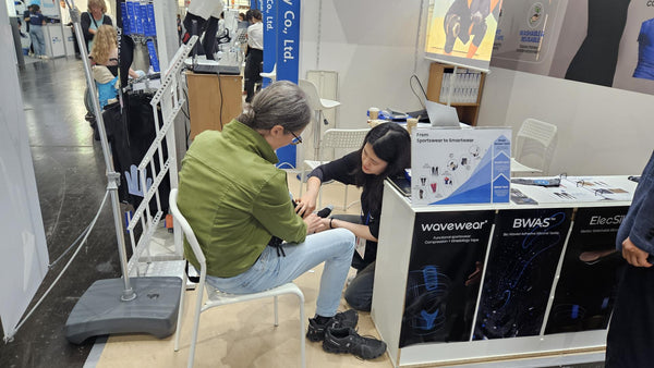 Booth worker measuring someones ankle to get them a right sized product