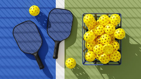 pickle ball rackets and waffle balls laying against a court floor