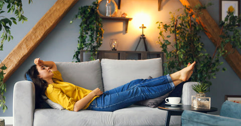 woman laying down on a couch looking exhausted and taking a break