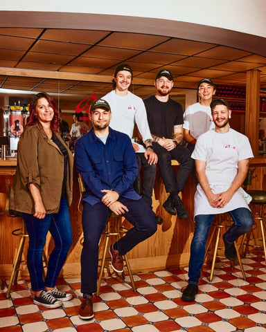 The upper management and chef team of Rizzo's House of Parm sitting together at the bar of Rizzo's House of Parm.