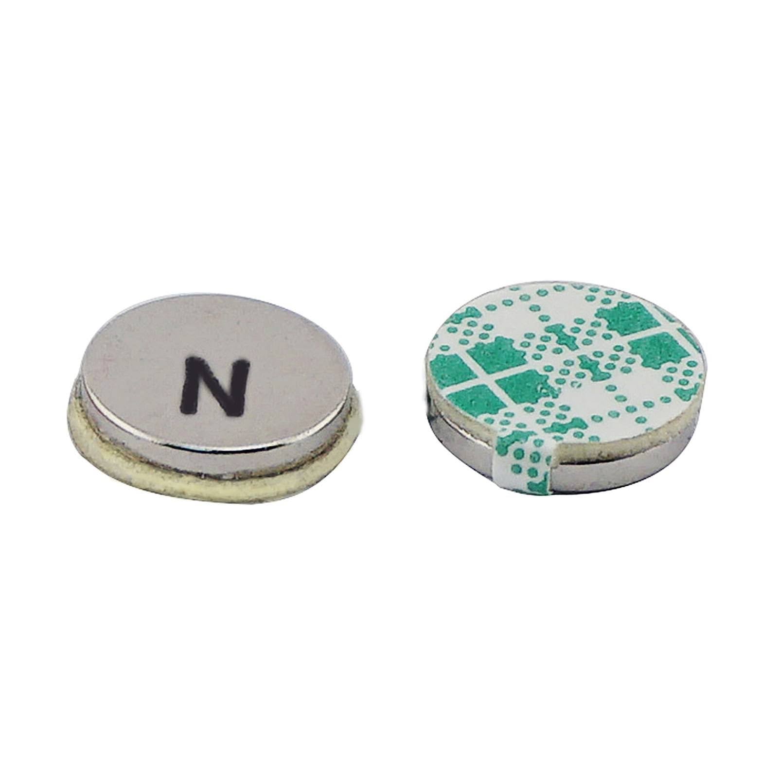 Two small round neodymium disc magnets with adhesive backing; one magnet displays the north polarity ("N"), and the other shows the peel-off 3M adhesive layer, ideal for mounting in crafts, DIY projects, and lightweight industrial uses.