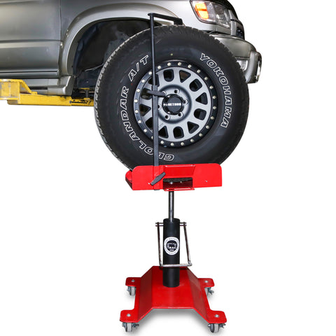 TRAC Tire Rotation Assistance Cart under the tire of a large SUV 