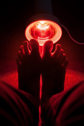 Red light therapy bulb focused on feet