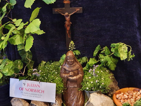 Close-up of a carving of Julian of Norwich and the stand label for table 9, sponsored by the Friends of Julian of Norwich.