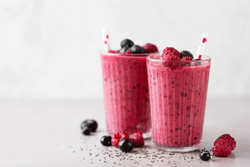 Two berry smoothies with straws