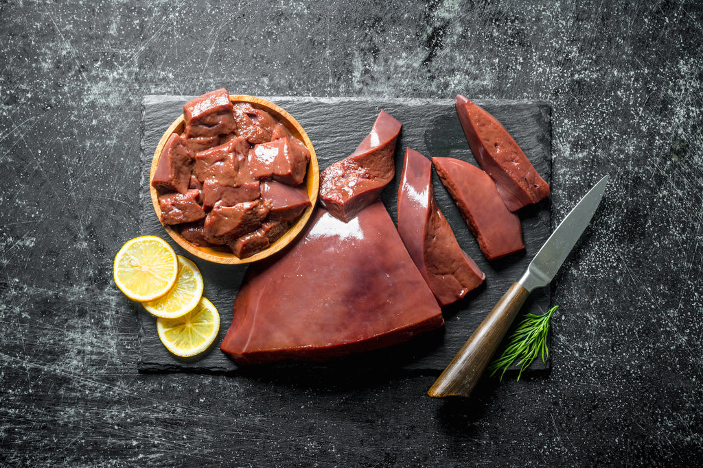 Raw liver next to rosemary and lemon