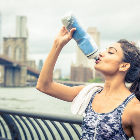 healthy female runner enjoying a hydrating salt and electrolyte drink