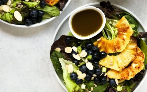 healthy salad dressing with vegetables, blueberries and nuts in a bowl