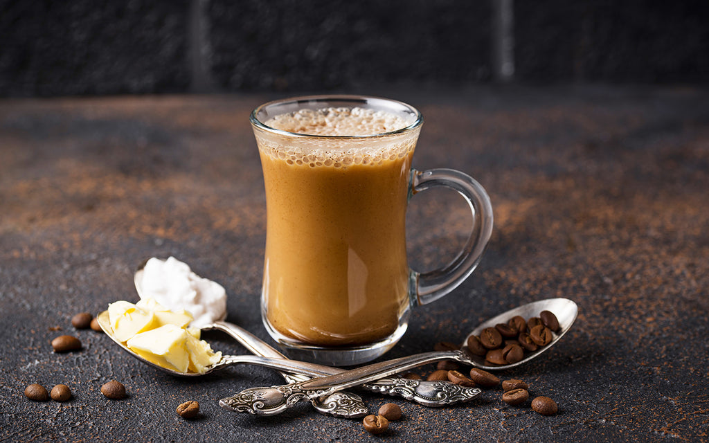 Bulletproof coffee UK: Coffee in a glass cup with spoons of coffee beans, butter and coconut oil