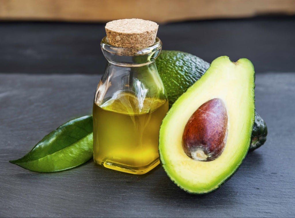 Avocado oil in a bottle with avocado fruit