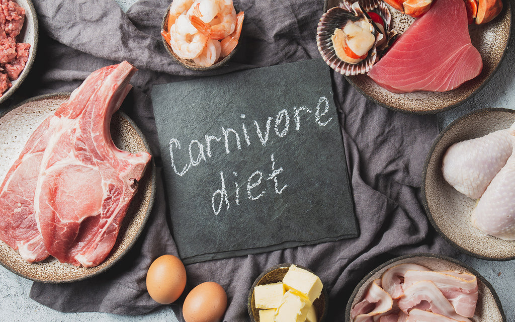 carnivore diet written on a board with different kinds of food around it