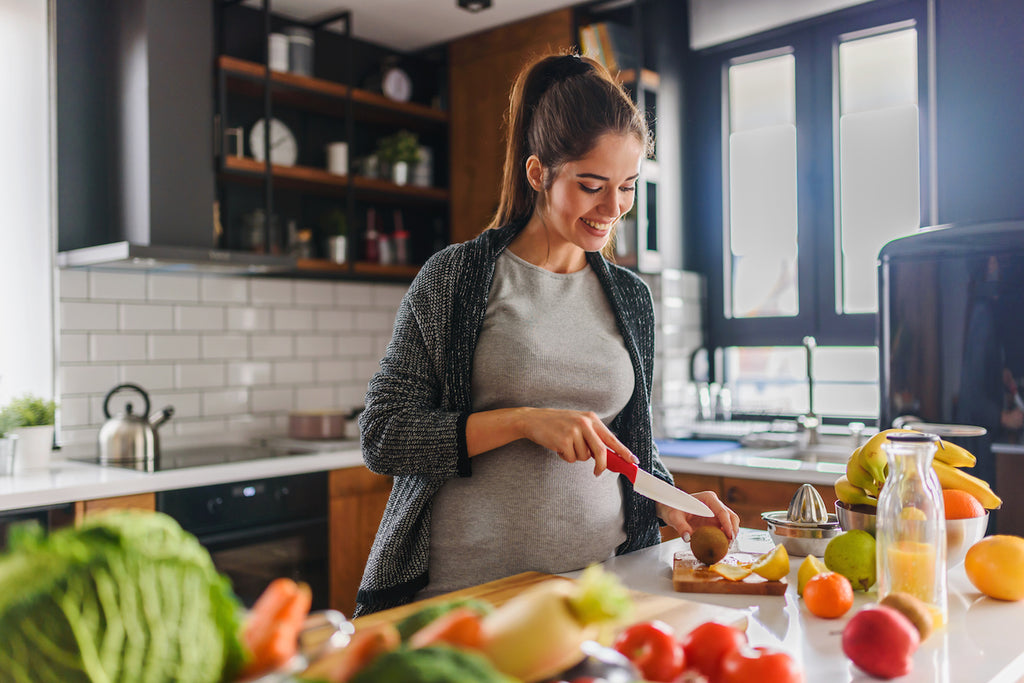 Pregnant woman cuts fruit