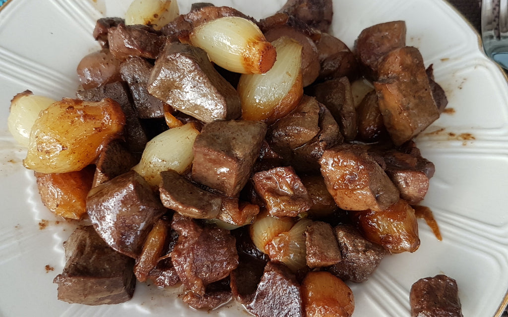 Kidney stew with onions on a white plate