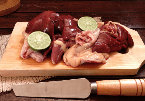 assorted offal on a wooden cutting board