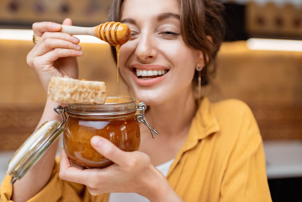 is honey paleo: woman holding a jar of honey