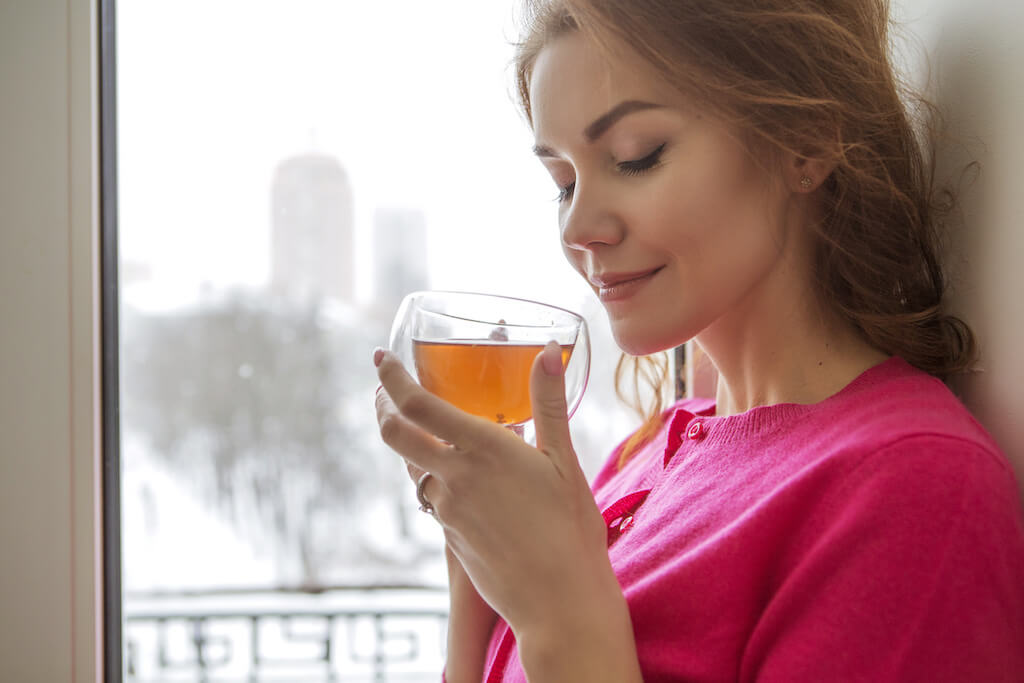 Woman holding a cup of bone broth