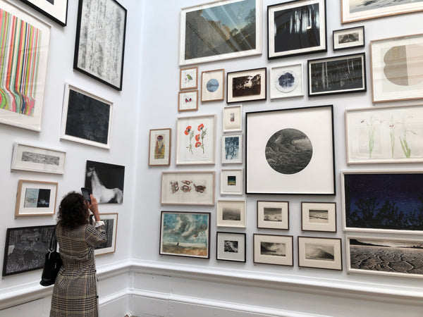 Visually impaired artist Bianca Raffaella uses her phone's zoom, to view Richard Spare's two artworks 'Greenfinch' and 'The Tiff' at the 2021 RA Summer Exhibition.