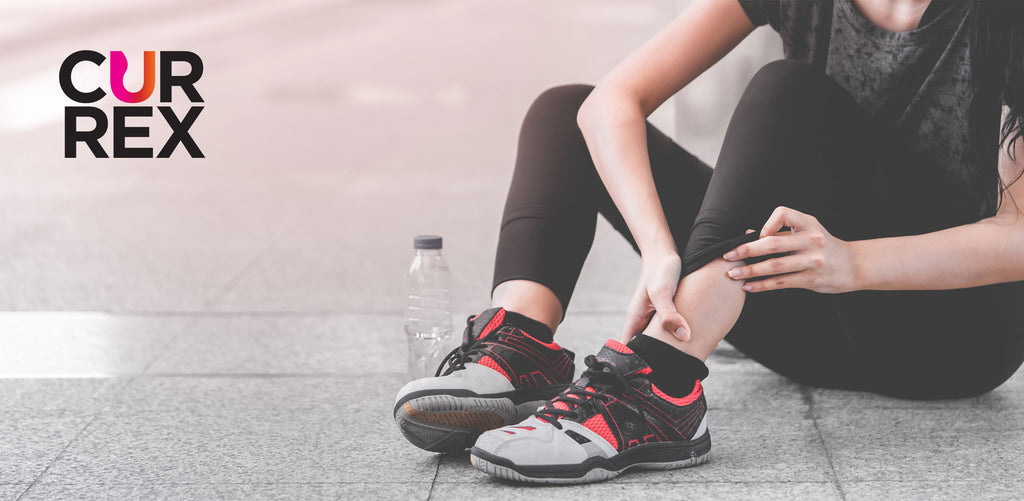 runner sitting on ground examining ankle and foot