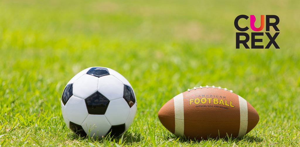 Soccer ball and a football on a field of green grass