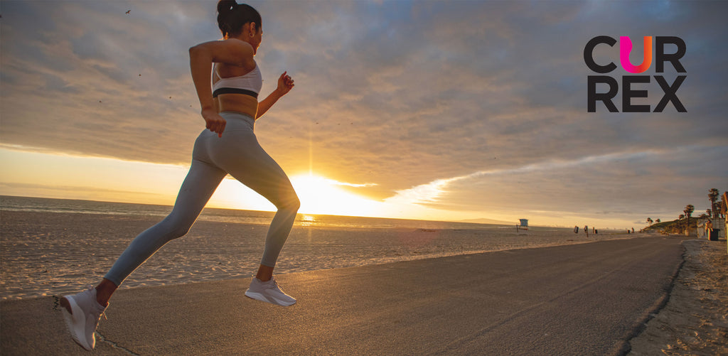 woman running on beachside path at sunset