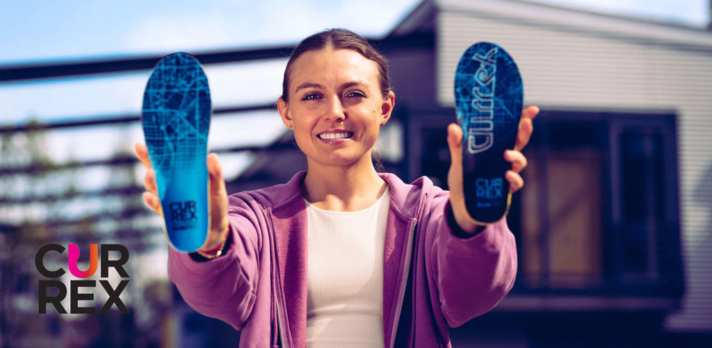 Woman holding two blue CURREX insoles