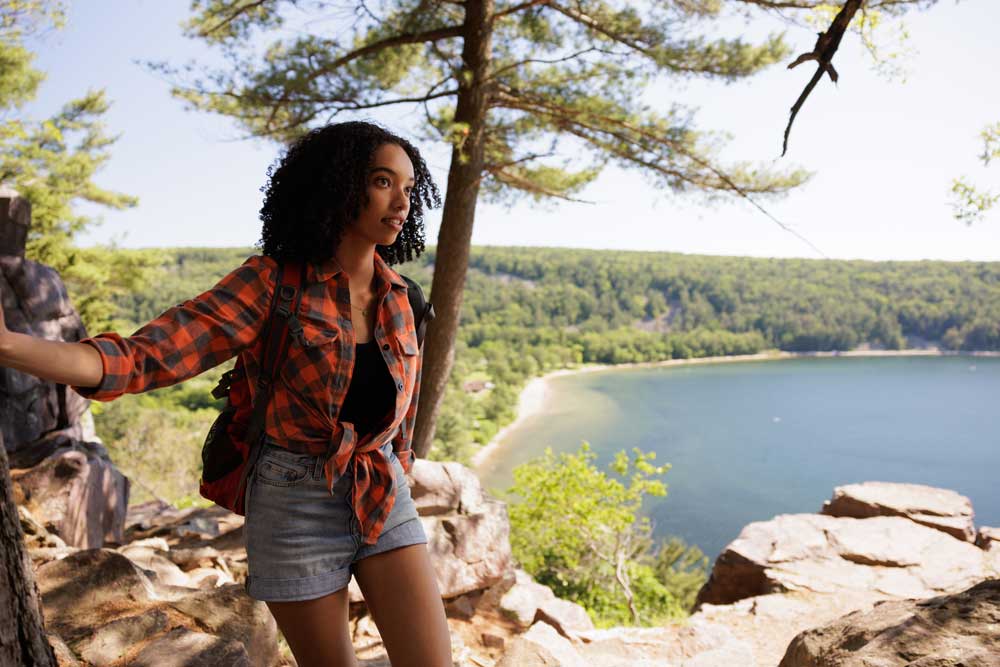 Woman hiking through woods on a clear sunny day