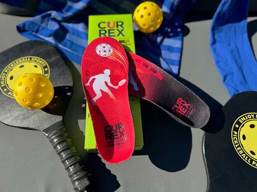 CURREX PICKLEBALLPRO Insoles sitting next to pickleball gear; pickleball paddles and pickleball ball