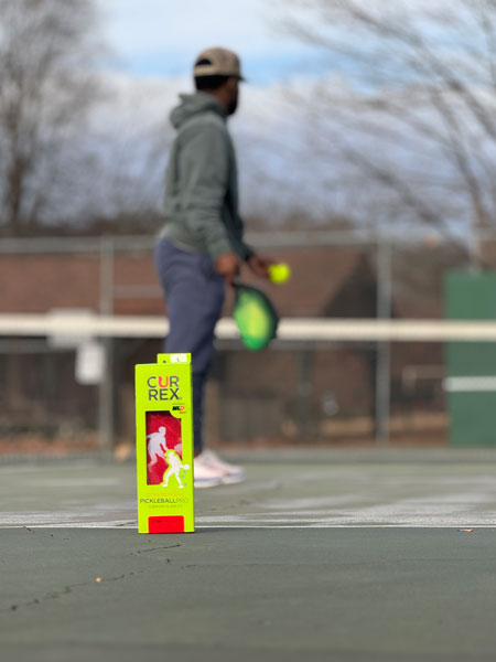 man on pickleball court behind green box of pickleball insoles