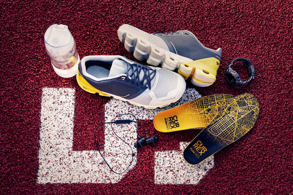 Running gear and yellow running insoles on red track