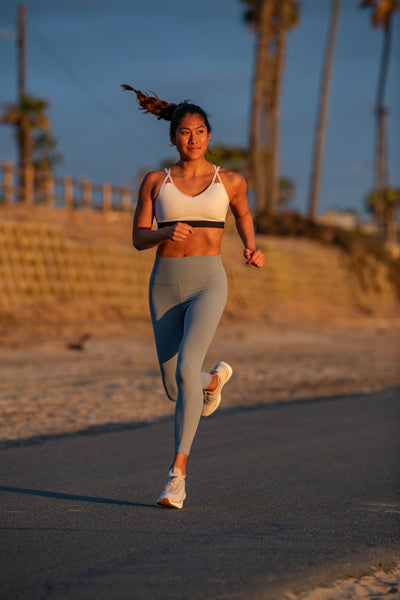 woman running beachside in sunset glow