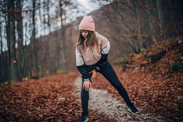 Woman stretching on forest path