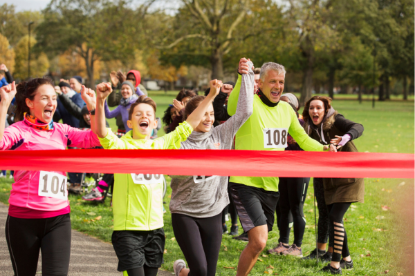 Group of people crossing the finish line at a community fall run